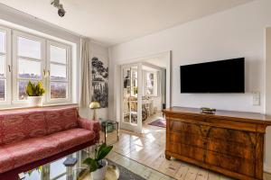 a living room with a red couch and a flat screen tv at Attendorner Burgblick in Attendorn
