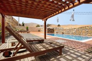 a wooden deck with a bench and a swimming pool at Casa del Valle in Betancuría