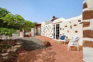 a house with a patio with chairs in the yard at Casa del Valle in Betancuría