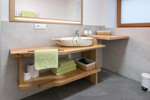 a bathroom with a sink and towels on a shelf at Gurschlerhof in Lasa +48 photos