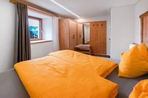 a bedroom with two beds and a window at Gurschlerhof in Lasa