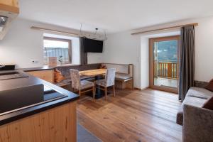 a kitchen and living room with a table and chairs at Gurschlerhof in Lasa