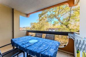 a balcony with a table and a large window at Appartement Andernos - Proche plage in Andernos-les-Bains