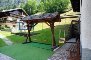 a swing set in a yard with a house at Residence Bonetti in Rabbi