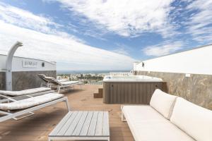 a balcony with white furniture and a view of the ocean at Nerja Luxury Apartment in Nerja