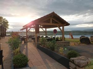 a wooden pavilion in a park next to a lake at Maison de Violette in Serrières-de-Briord