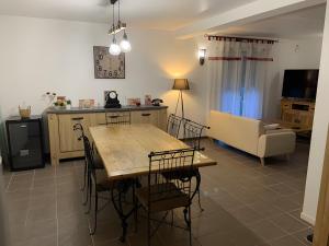 a kitchen and living room with a table and chairs at Maison de Violette in Serrières-de-Briord