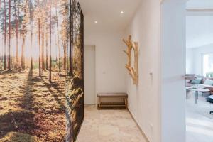 a hallway with a wall mural of a forest at Ferienwohnung Waldzauber Lennestadt in Lennestadt +17 photos