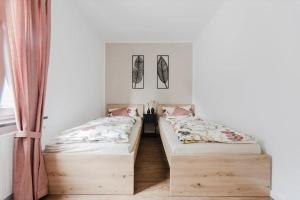 two beds in a room with white walls at Ferienwohnung Waldzauber Lennestadt in Lennestadt