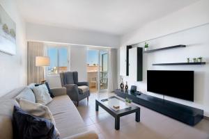 a living room with a couch and a flat screen tv at Moderno e acolhedor com vista mar in Quarteira