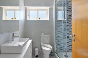 a bathroom with a sink toilet and a glass shower at Moderno e acolhedor com vista mar in Quarteira +14 photos