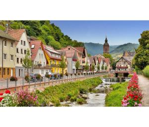 a town with a river and buildings and a church at Ferienwohnung Huber in Oppenau