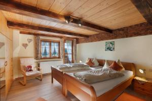 a bedroom with two beds in a room with wooden ceilings at Krährbauernhof mit Hofladen in Hornberg