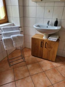 a bathroom with a sink and a chair at Ferienwohnung Huber in Oppenau