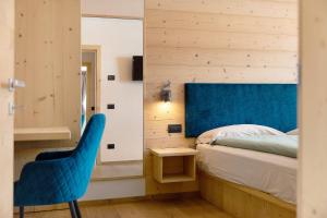 a bedroom with a blue chair and a bed at Alpi Flo Chalet in Livigno