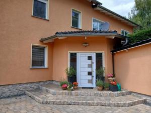 a orange house with a white door and potted plants at Ferienwohnung Jacobi in Weißenfels