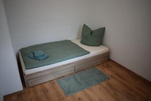 a small bed with a green blanket and a pillow at Ferienwohnung Jacobi in Weißenfels