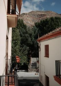 a view of a mountain from between two buildings at Casa de Manuel in Pinos Genil