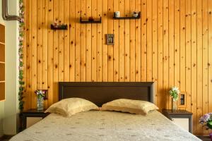 a bedroom with a bed and a wooden wall at Vangelis studio 2 in Kefalonia
