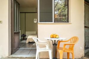 a table with two chairs and a table with fruit on it at Vangelis studio 2 in Kefalonia