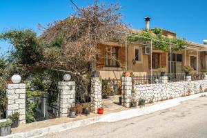 a house with a stone fence in front of it at Vangelis studio 2 in Kefalonia +11 photos