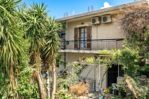 an apartment building with palm trees in front of it at Vangelis studio 2 in Kefalonia