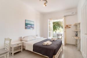 a bedroom with a bed and a chair and a window at Green Retreats 5 Paros in Isterni