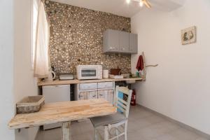 a small kitchen with a table and a microwave at Green Retreats 5 Paros in Isterni