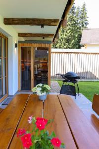 a wooden table with flowers on a patio at Chalet Almblick mit Sauna in Tauplitz