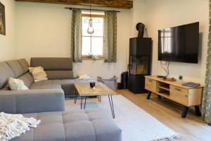 a living room with a couch and a tv at Chalet Almblick mit Sauna in Tauplitz