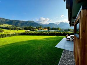 a porch of a house with a green lawn at Chalet Almblick mit Sauna in Tauplitz