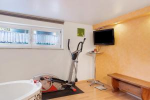 a living room with a treadmill and a tv at Ferienwohnung Lemke in Donaueschingen