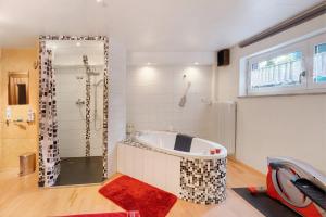 a large bathroom with a tub and a shower at Ferienwohnung Lemke in Donaueschingen