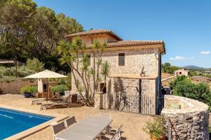 a stone house with a swimming pool in front of it at Finca Estrella in Artá