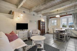 a living room with a couch and a tv and a table at Ferienwohnungen Am Westerdeich in Rodenäs