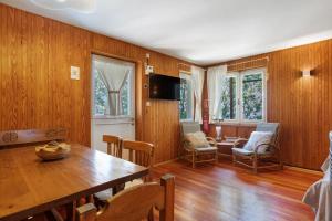 a dining room with wooden walls and a table and chairs at Appartamenti Petite Cerise in Pila