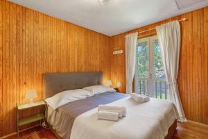 a bedroom with a bed with wooden walls and a window at Appartamenti Petite Cerise in Pila