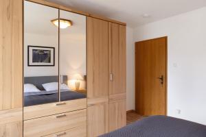 a bedroom with a large wooden cabinet with a mirror at Haus Lerchenweg in Bad Wildungen
