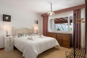 a bedroom with a large white bed and a window at Apartamento Cipreses in Puerto del Carmen