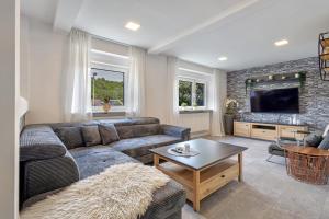 a living room with a couch and a table at Ferienwohnung Högenbachtal in Pommelsbrunn