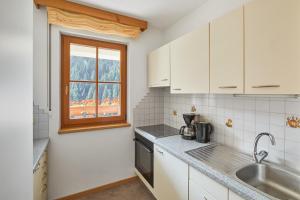a white kitchen with a sink and a window at Jaufenspitze Blasighof in Racines +15 photos