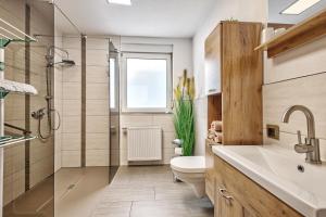 a bathroom with a toilet and a shower and a sink at Ferienwohnung Högenbachtal in Pommelsbrunn +19 photos