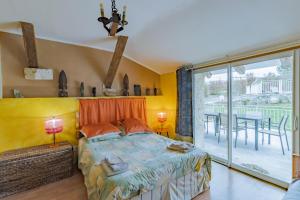 a bedroom with a bed and a balcony with a table at Maison Sébastien in Saint-Pierre-de-Côle +23 photos