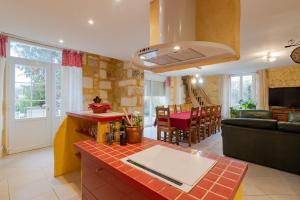 a kitchen and living room with a couch and a table at Maison Sébastien in Saint-Pierre-de-Côle