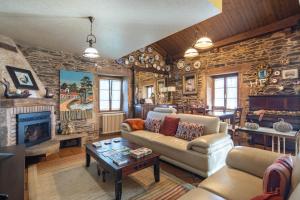 a living room with a couch and a fireplace at Casa Da Puza in Forcarei