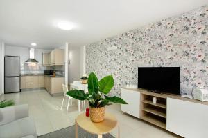 a living room with a flat screen tv on a wall at Sunrise Arinaga in Arinaga