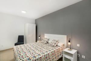 a bedroom with a large bed and a chair at Sunrise Arinaga in Arinaga