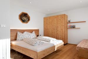 a bedroom with a wooden bed with two pillows at Kardinerhof in Collalbo