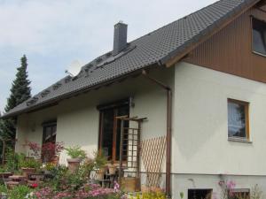 una casa bianca con il tetto nero di Adrett a Hermsdorf