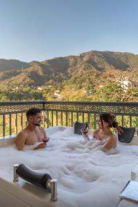 a man and woman sitting in a hot tub at Perfectstayz Premium Dehradun at Rajpur road in Dehradun